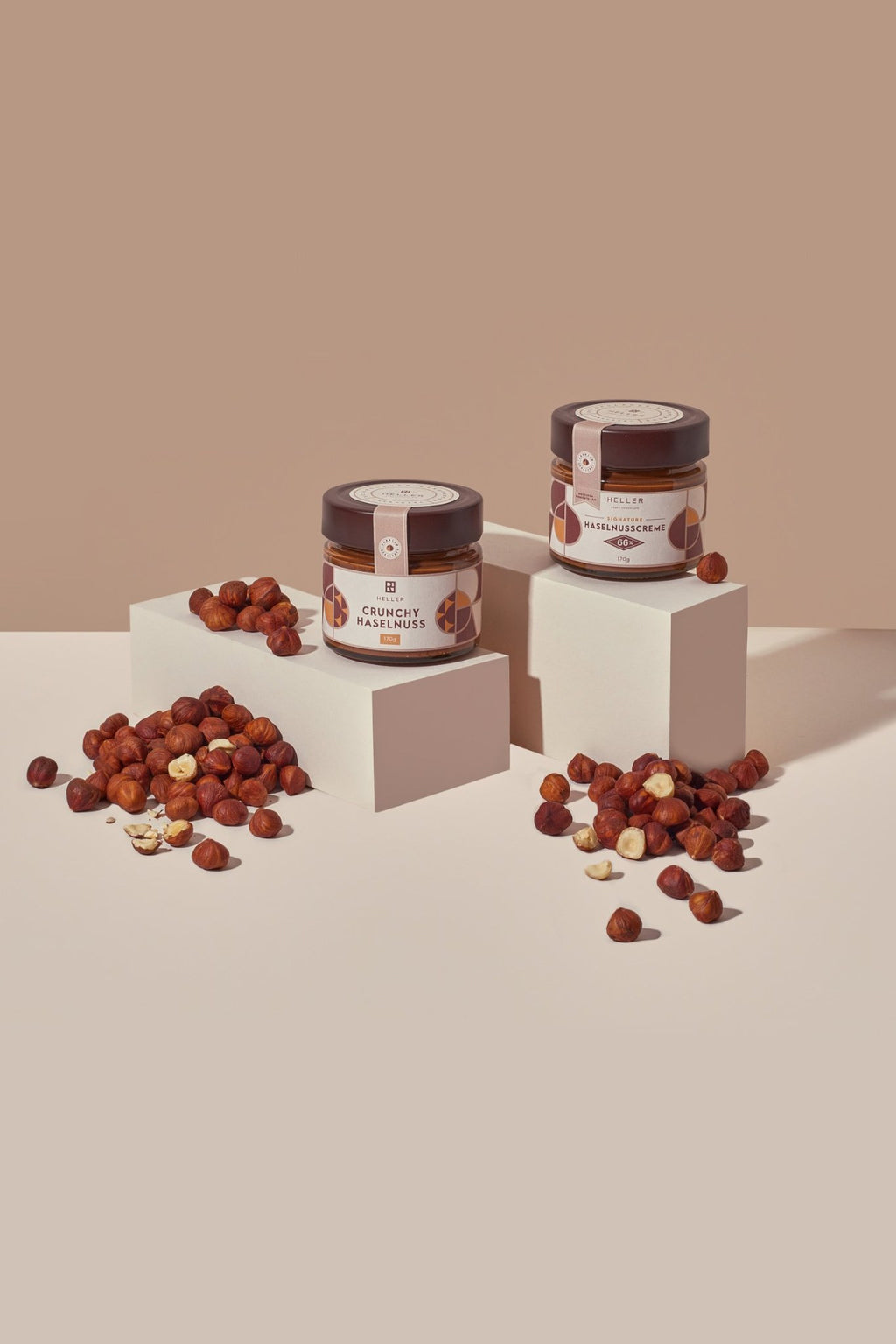 Crunchy Haselnuss und Signature Haselnusscreme auf Podesten mit Haselnüssen